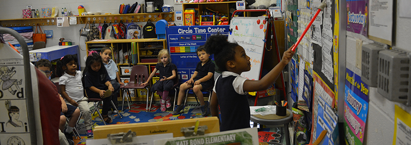 Girl standing and reading from black board