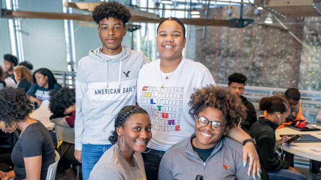 Students standing and sitting smiling at camera